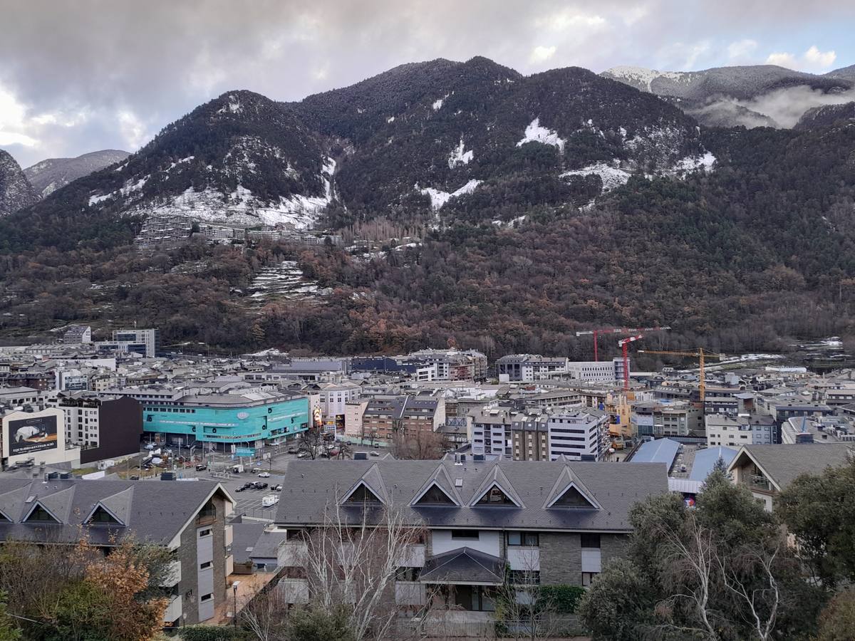 Andorra la Vella's dense rooftops fill the valley floor beneath snow-dusted mountain slopes