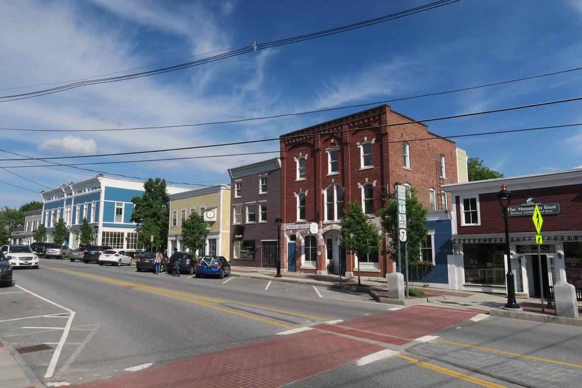 Main Street in Manchester Center on a summer day, from the 1890s brick block to the Mountain Goat outdoor-gear shop on historic Route 7A